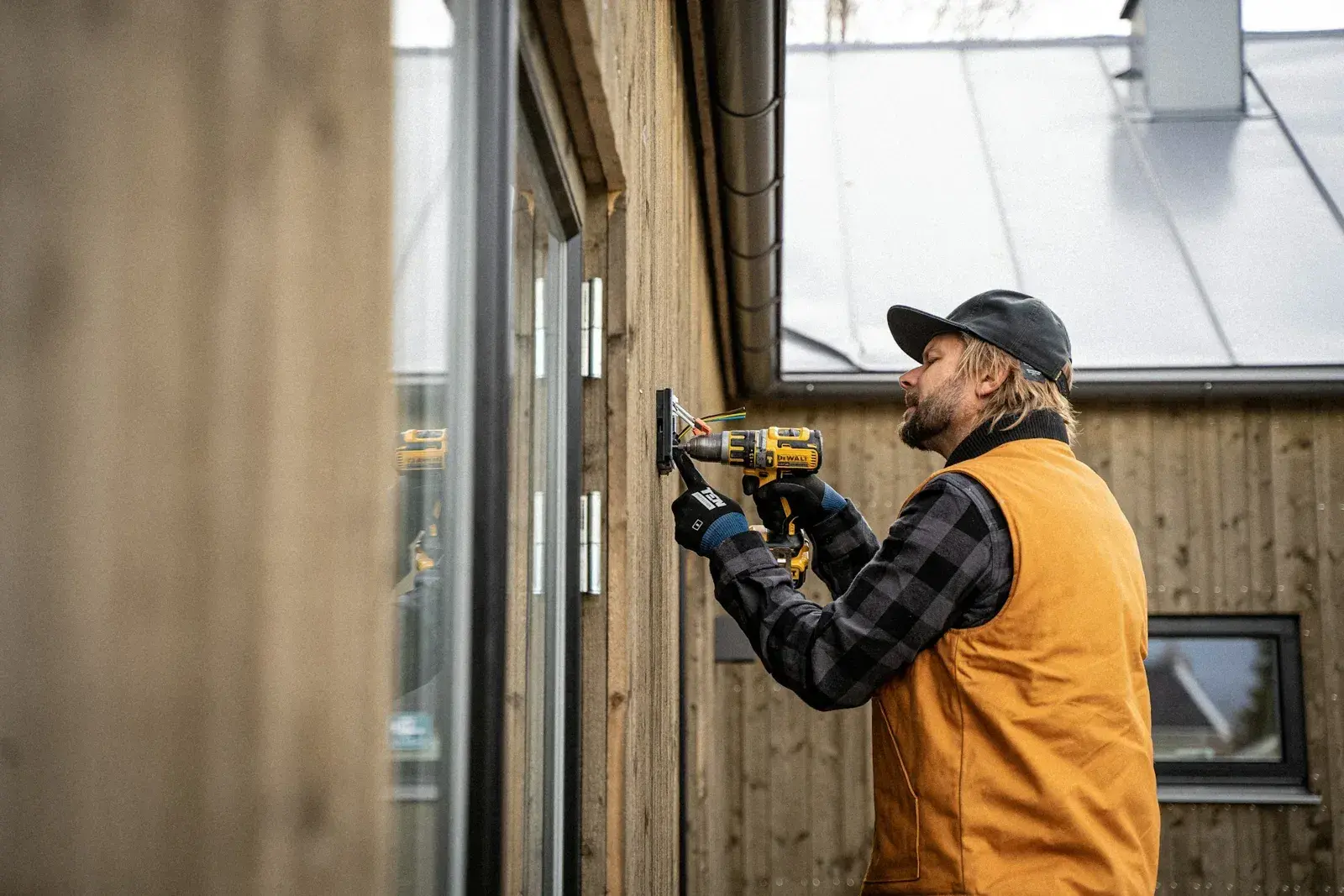 Elektriker som arbeider på en husvegg